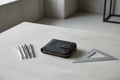 Portefeuille noir à plat sur béton